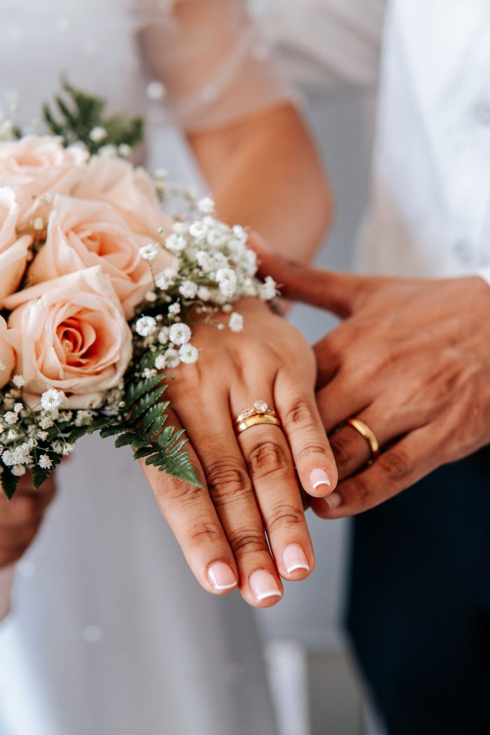 An elegant arrangement of wedding rings beside a delicate bouquet represents love and togetherness.