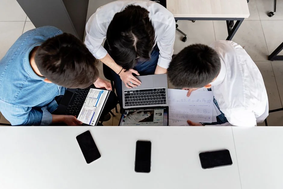 A contemporary tablet showing a search engine logo sits beside a wireless keyboard on a wooden desk.